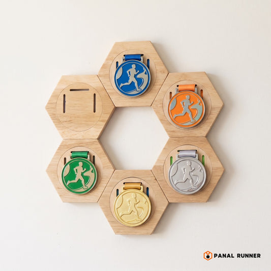 Panal de 6 medalleros hexagonales con medallas en una pared blanca